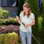 Frau montiert Gardena combisystem-Kleingrubber an Stiel im Garten.