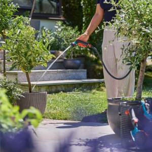 Gartenszene: Person bewässert Pflanze mit Gardena Multi-Brause Indoor Set Classic.