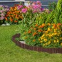 Dunkelbraune, flexible Beeteinfassung aus Tannenholz trennt Rasen von Blumenbeet mit bunten Blüten im Garten.