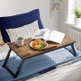 Vintagebrauner Songmics Laptopständer (71x35x23cm) mit Essen und Buch auf einem Bett.