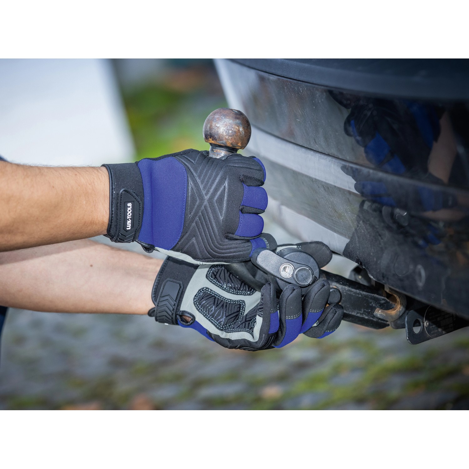 Hände mit LUX Arbeitshandschuhen Tough Gr. 10 bei der Arbeit an einer Anhängerkupplung.