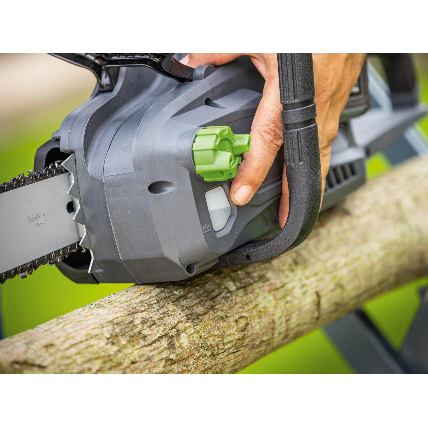 LUX-TOOLS Akku-Kettensäge A-KS-2x20/405 in Aktion, Detailaufnahme von Hand und Bedienelementen.