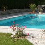 Rechteckiger Steinbach Styropor Pool im Garten mit blauer Wasseroberfläche und Randsteinen.