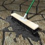 Auftragen von MEM Fix-Fertig-Fugenmörtel Basalt mit einem Besen auf Pflastersteine.