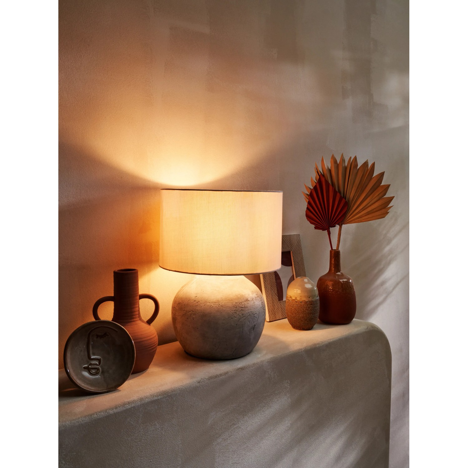 Dekorative orange Vase Ancient Secrets, 20 cm, auf einem Tisch mit Lampe und Deko.