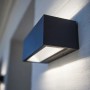 Moderne, anthrazitfarbene Lutec LED-Außenwandleuchte Gemini an einer Wand.