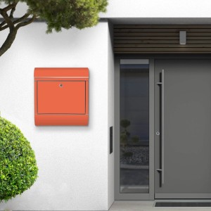 Orangefarbener Banjado Edelstahl Briefkasten mit Zeitungsfach an einer weißen Hauswand.