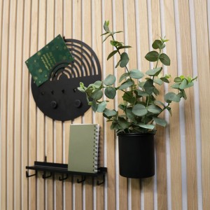 Schwarzer Denpanels Aufbewahrungsbecher mit Pflanze an Akustikpaneelwand.