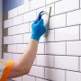 Verfugen von weißen Fliesen mit Knauf Flexfuge smart, Fugenmörtel in Weiß wird mit Schwammbrett aufgetragen.