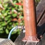 Detailaufnahme: Gre Solardusche in Holzoptik mit Gartenschlauchanschluss.