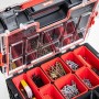 Offener, schwarzer QBRICK Sortimentskasten Pro mit transparentem Deckel und rotem Innenleben, gefüllt mit Schrauben.