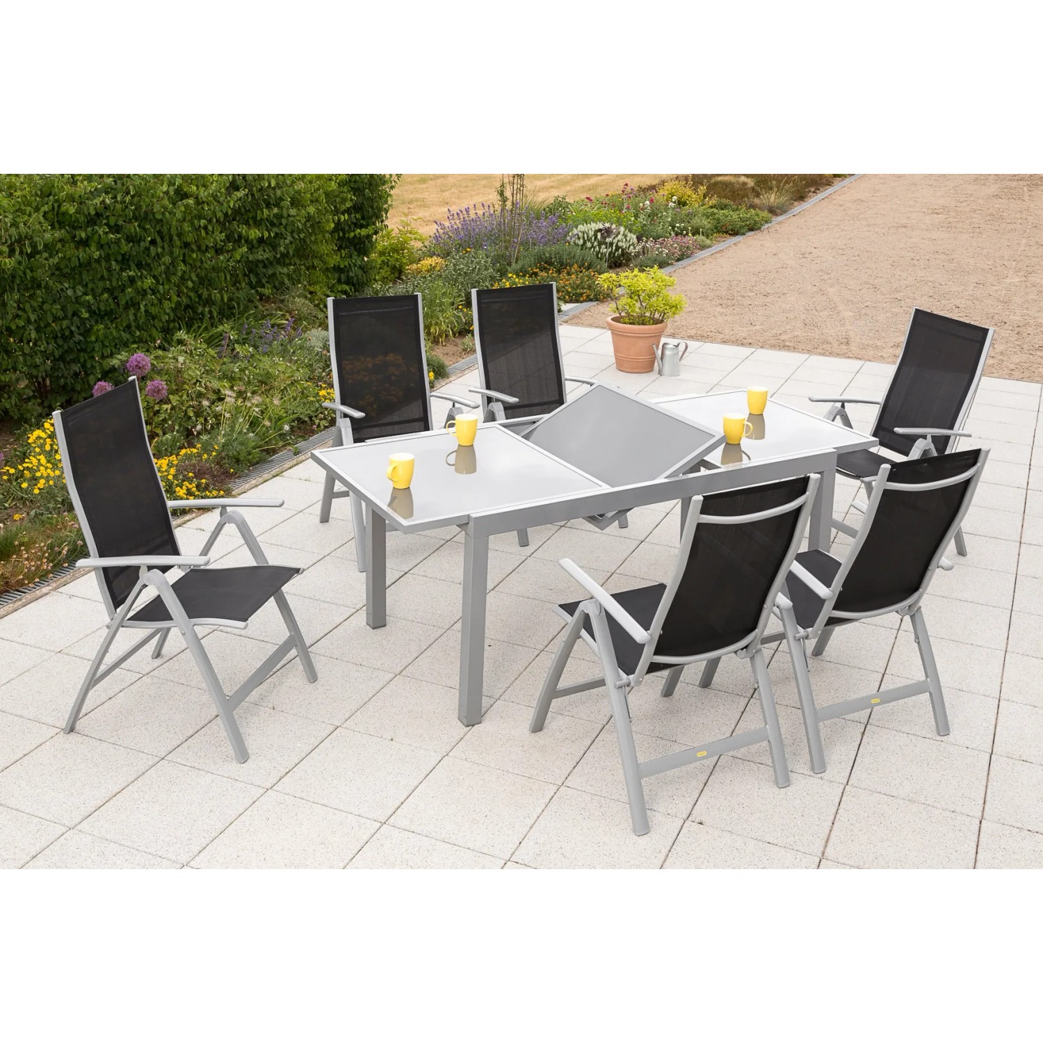 7-teiliges Gartenmöbel-Set Carrara in Schwarz mit Ausziehtisch (160/220x90 cm) auf Terrasse.