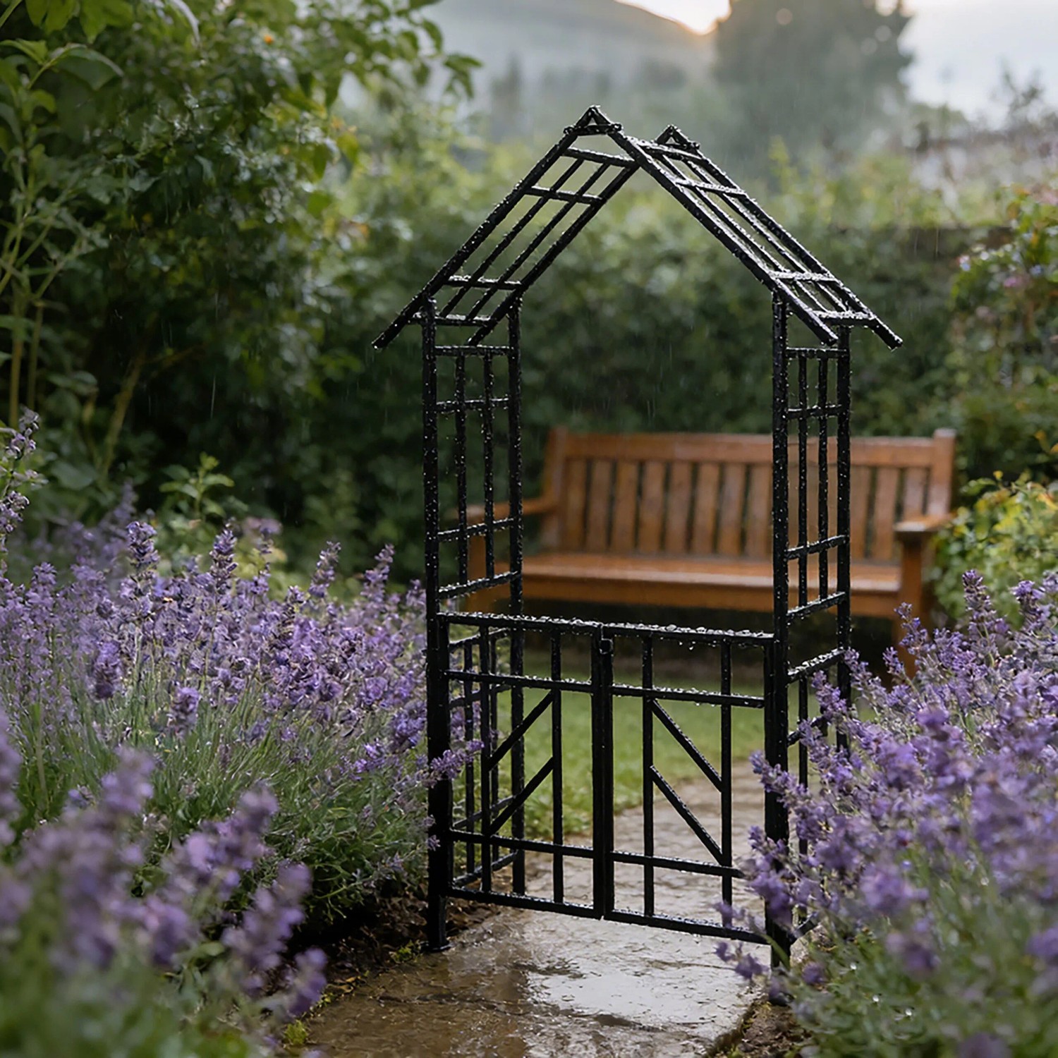 Schwarzer Rosenbogen mit Tor im Garten, umrankt von Lavendel. Rankhilfe aus Eisen, abschließbar.