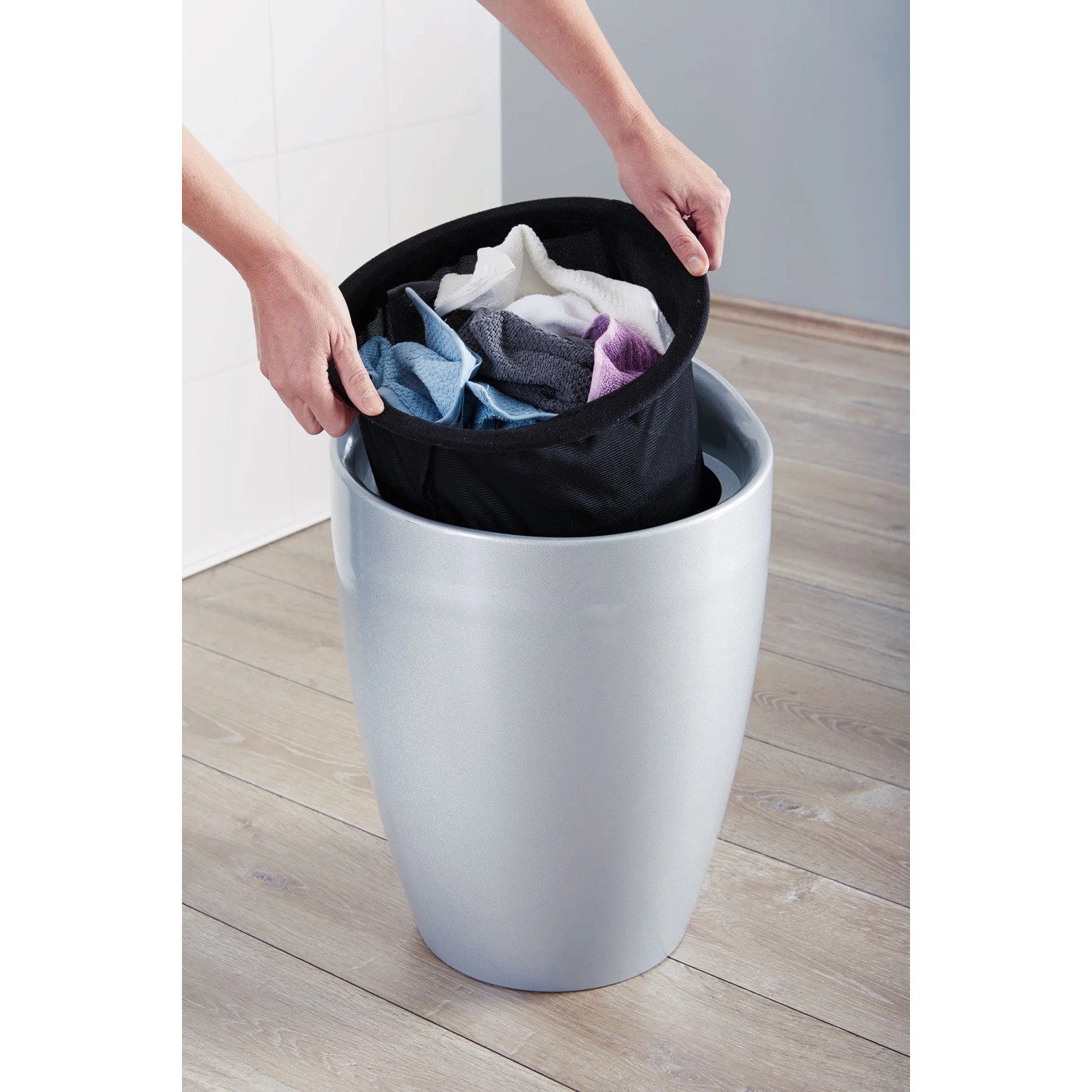 Silberner Wenko Badhocker Candy mit Wäschesack (20 l) wird befüllt.