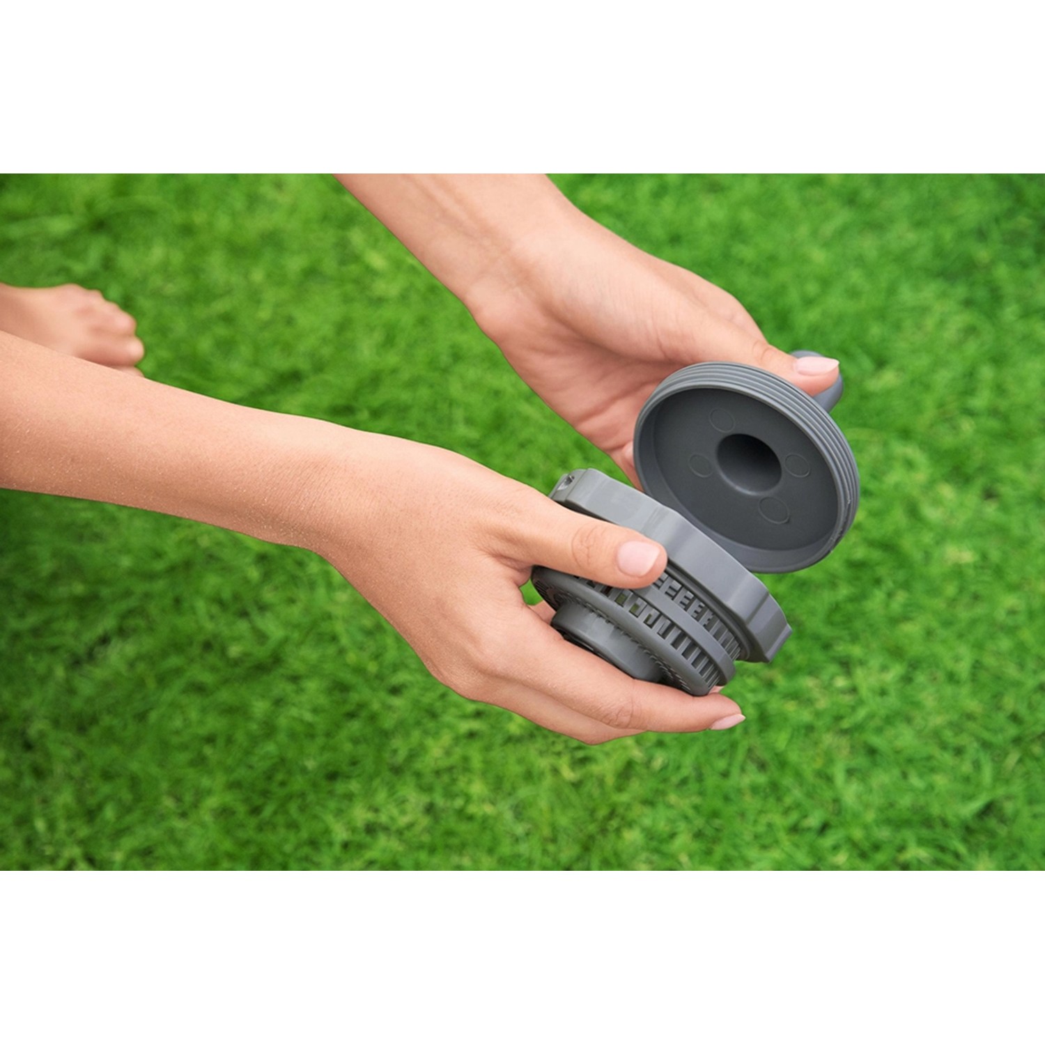 Detailaufnahme des Flowclear Aquasweeper Poolsauger-Filters in Händen vor Rasen.
