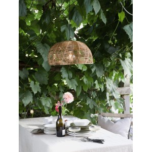 PR Home Mayla Außenleuchte aus Rattan über einem gedeckten Tisch im Garten.