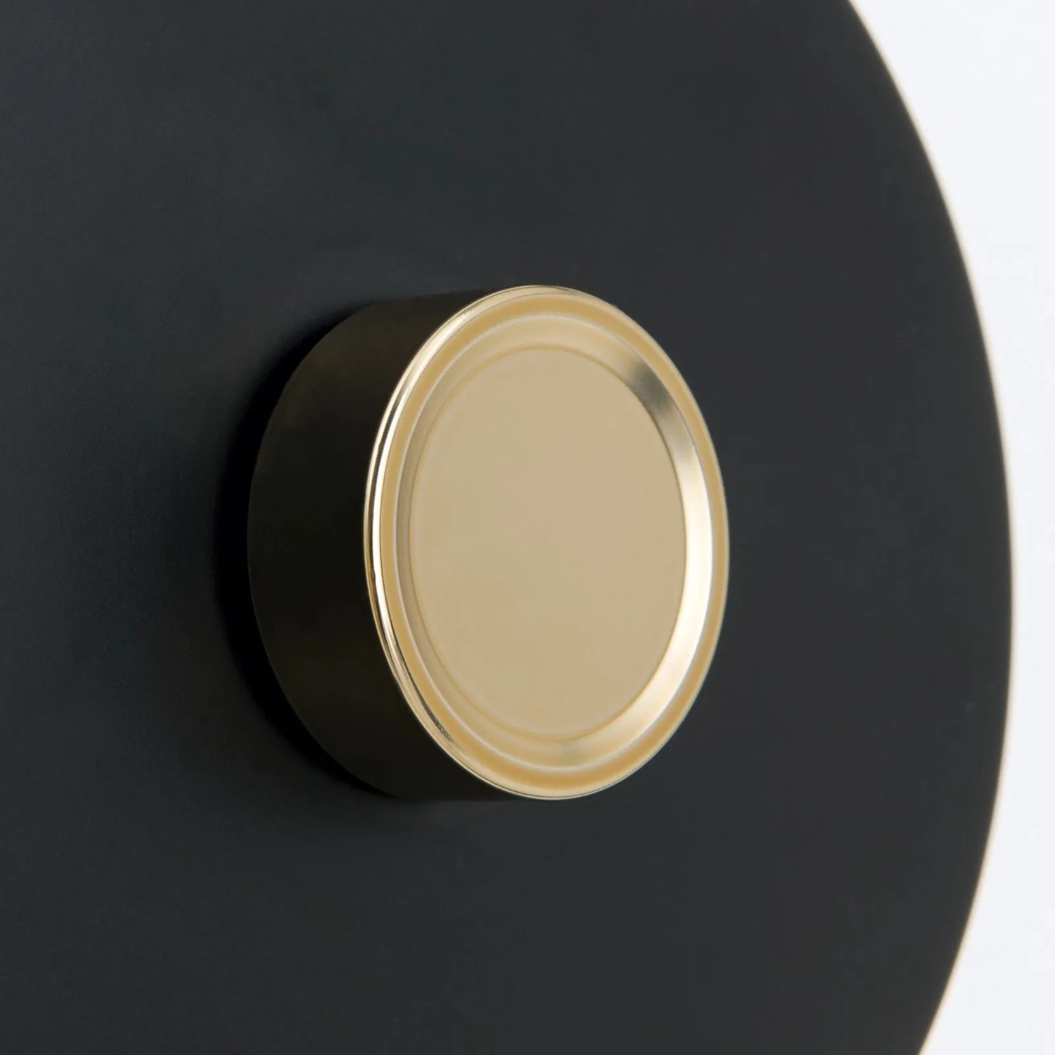 Detailaufnahme: Schwarze Orion Wandleuchte mit goldenem Dimmer. Elegante Lampe für stimmungsvolles Licht.