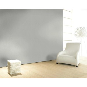 Helle Vliestapete „Farbenspiel Hellgrau“ an Wand im Wohnraum mit Sessel.