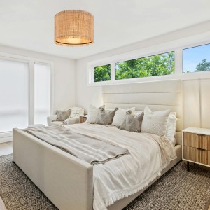 Briloner Deckenleuchte Swing Nature, Ø 40 cm, mit Strohschirm in einem Schlafzimmer.