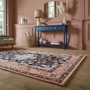 Flair Rugs Wollteppich Blossom Schwarz-Rosa mit traditionellem Blumendesign auf Holzfußboden im Wohnzimmer.