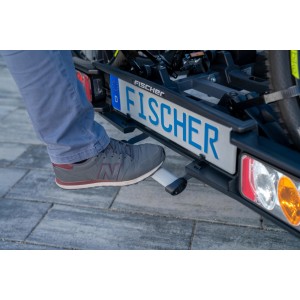 Person betätigt Fußpedal am Fischer Kupplungs-Fahrradträger Proline Evo zum Abklappen.