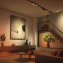 Schwarze Philips Hue Perifo LED-Spots an Schiene im Wohnraum mit Ambiente-Beleuchtung.