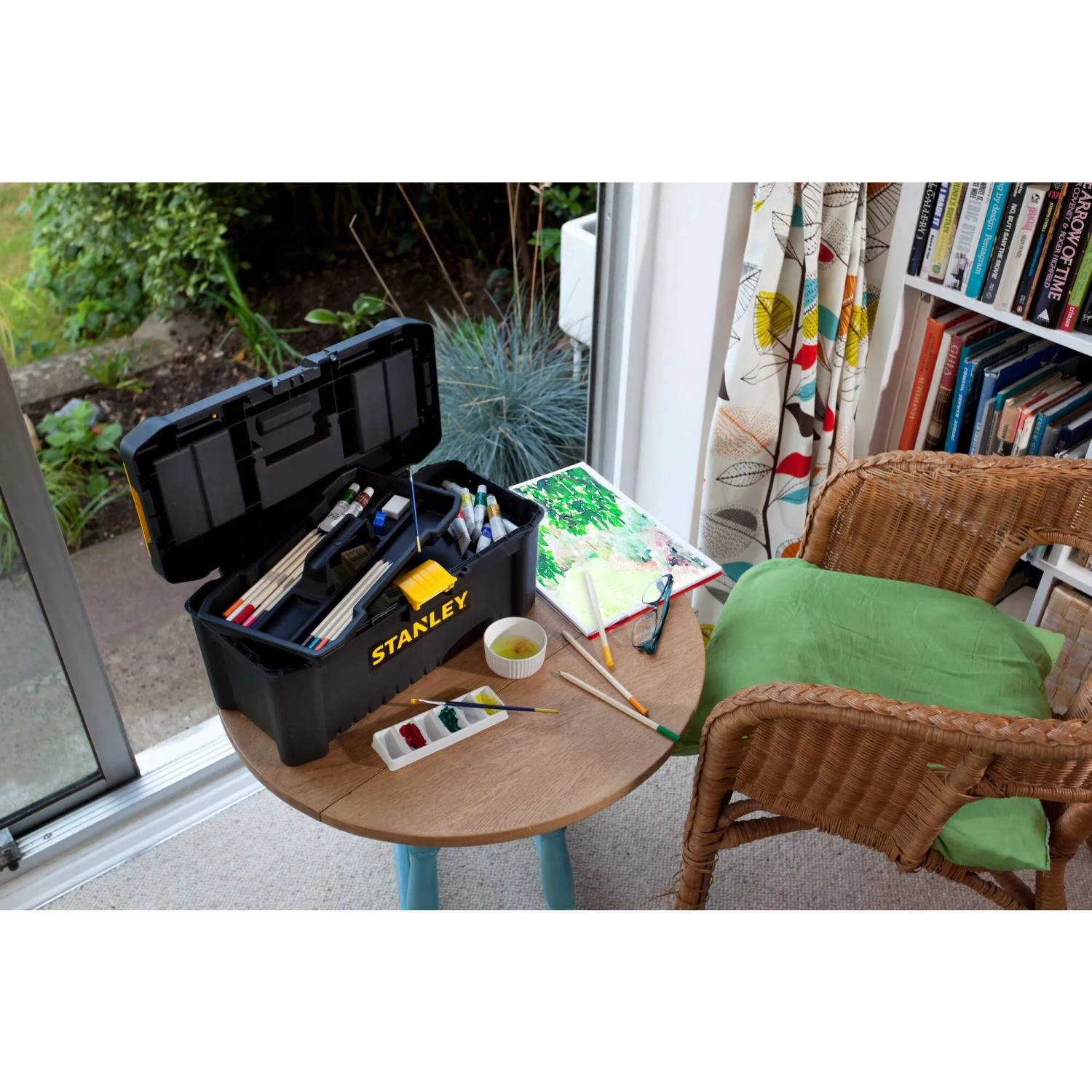 Stanley 16 Zoll Kunststoffbox Essential, geöffnet, mit Malutensilien auf Tisch.