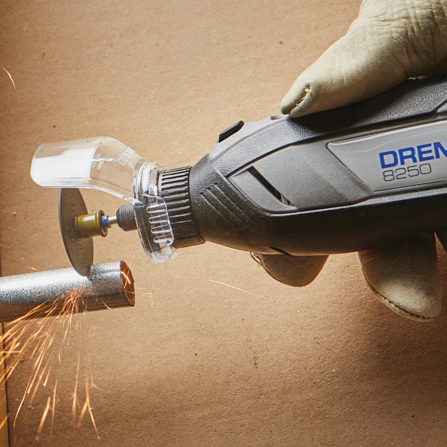 Dremel Akku-Multitool 8250-5 beim Schneiden eines Metallrohrs mit Funkenflug.