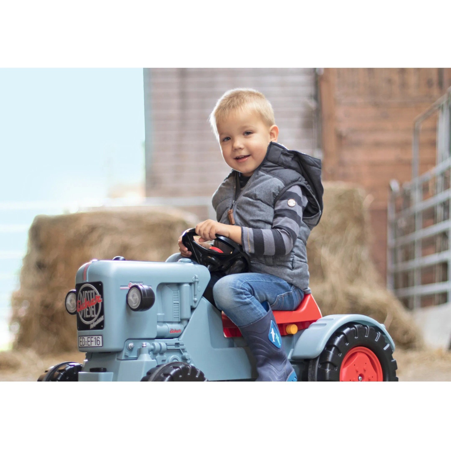 Kind auf blauem BIG Traktor Eicher Diesel ED 16 Trettraktor mit Kettenantrieb.