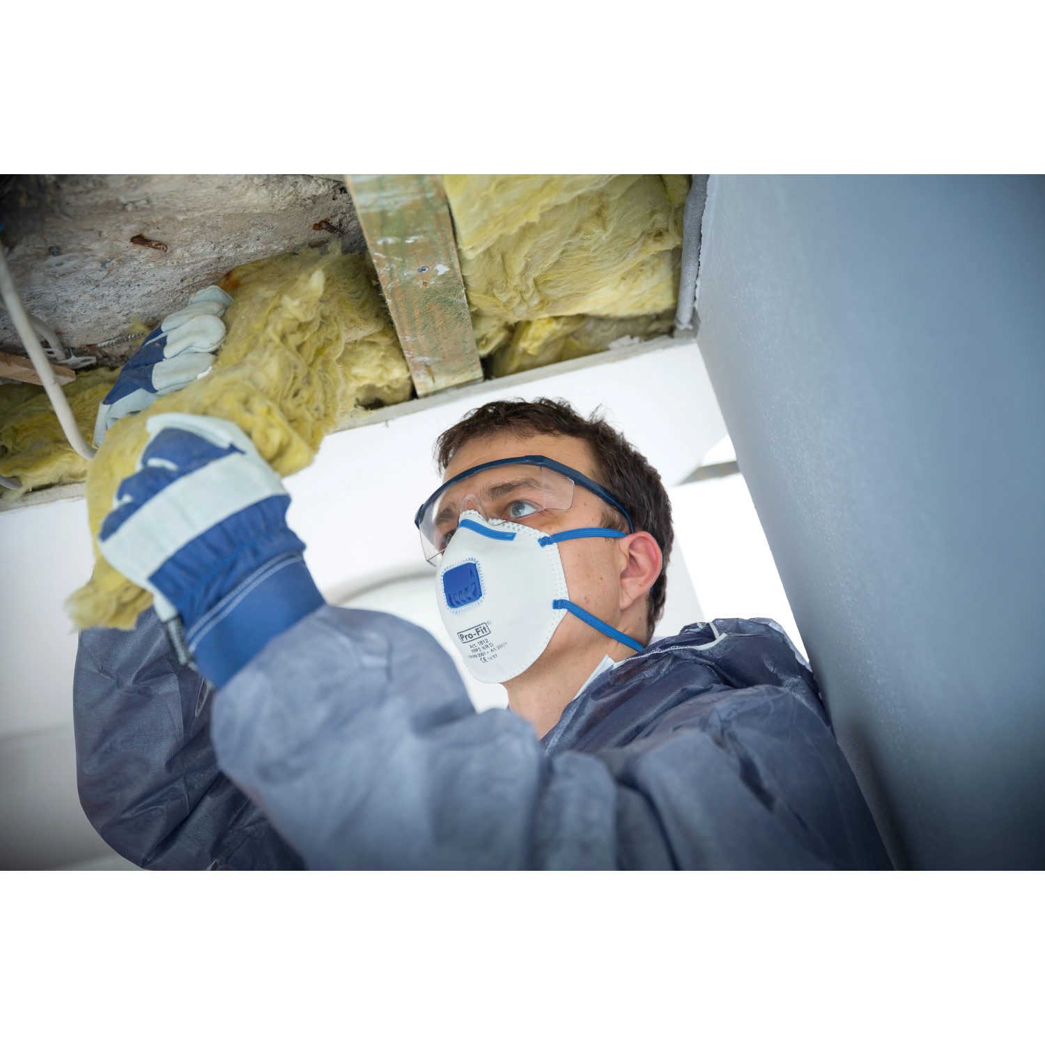 Mann mit LUX FFP2 Ventilmaske beim Dämmen. Atemschutz für Handwerker.