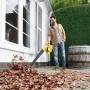 Mann nutzt gelben Kärcher Akku-Laubbläser LBL 4 Battery zum Laub entfernen vor einem Haus.