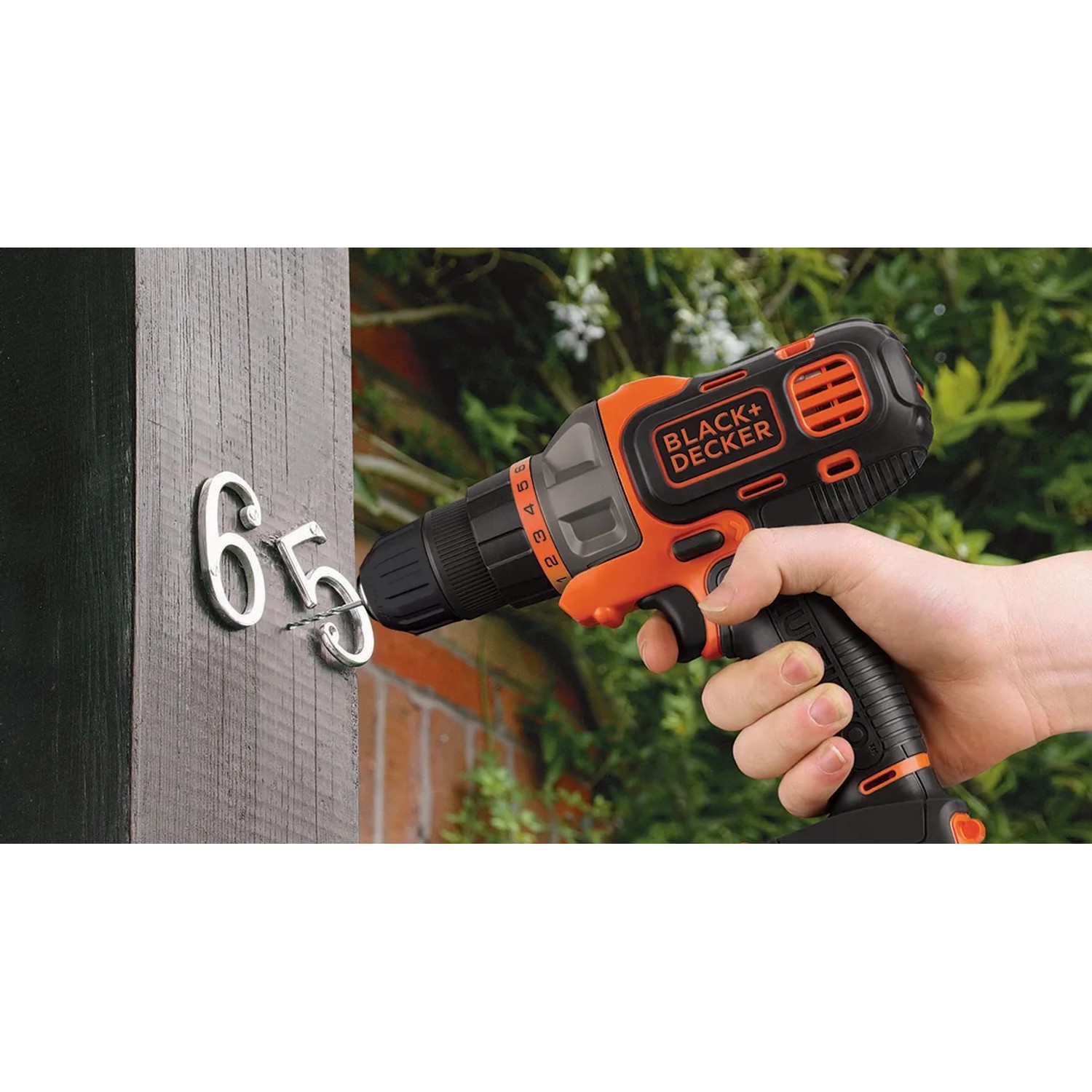 Black+Decker Multievo Akku-Multifunktionswerkzeug beim Schrauben einer Hausnummer.