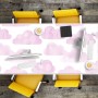 Schreibtischunterlage mit rosa Wolkenmuster auf Holztisch, umgeben von gelben Stühlen. Ideal für Büro & Homeoffice.