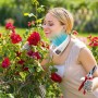 Frau mit Livington Cool2Go Klimagerät im Garten mit Rosen.
