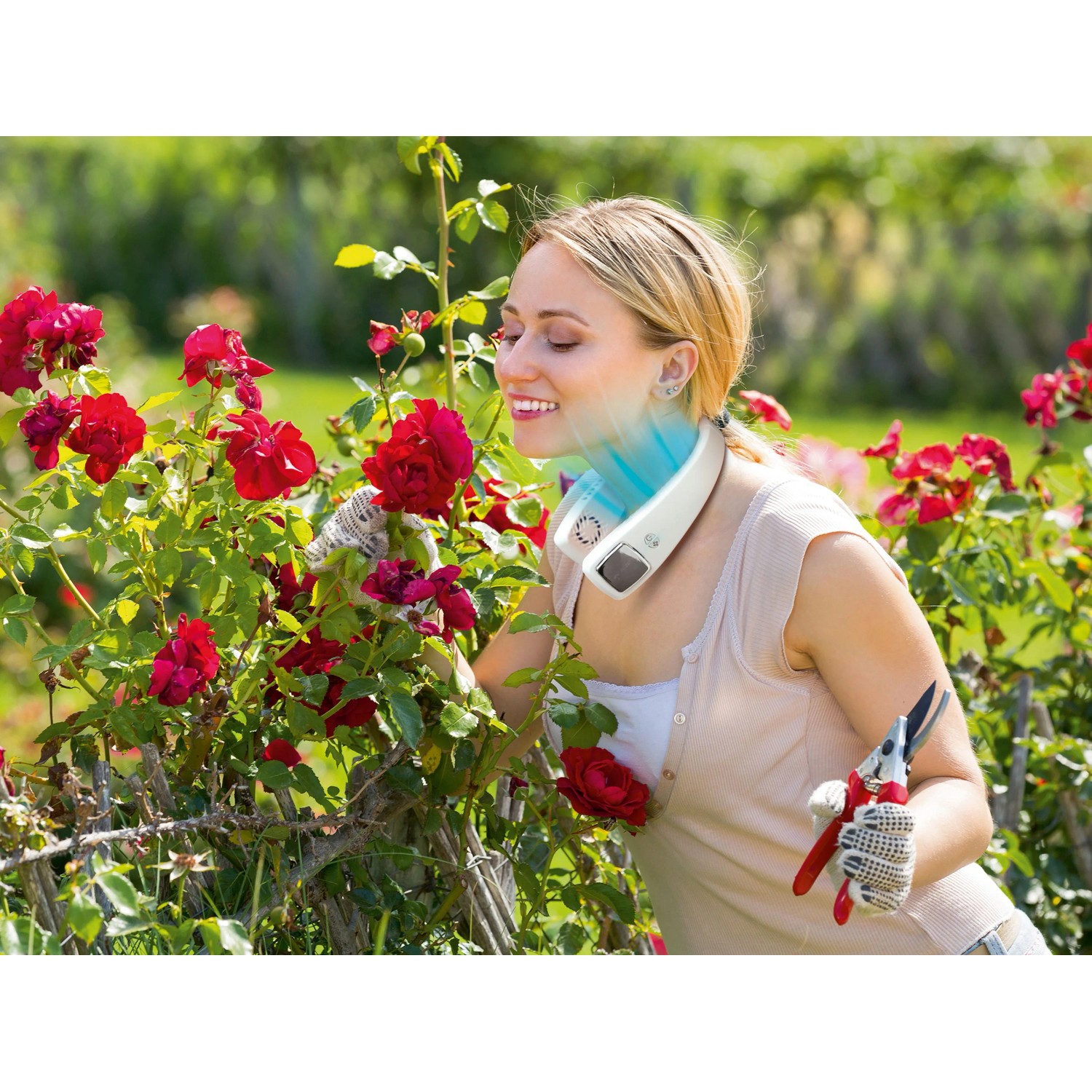 Frau mit Livington Cool2Go Klimagerät im Garten mit Rosen.