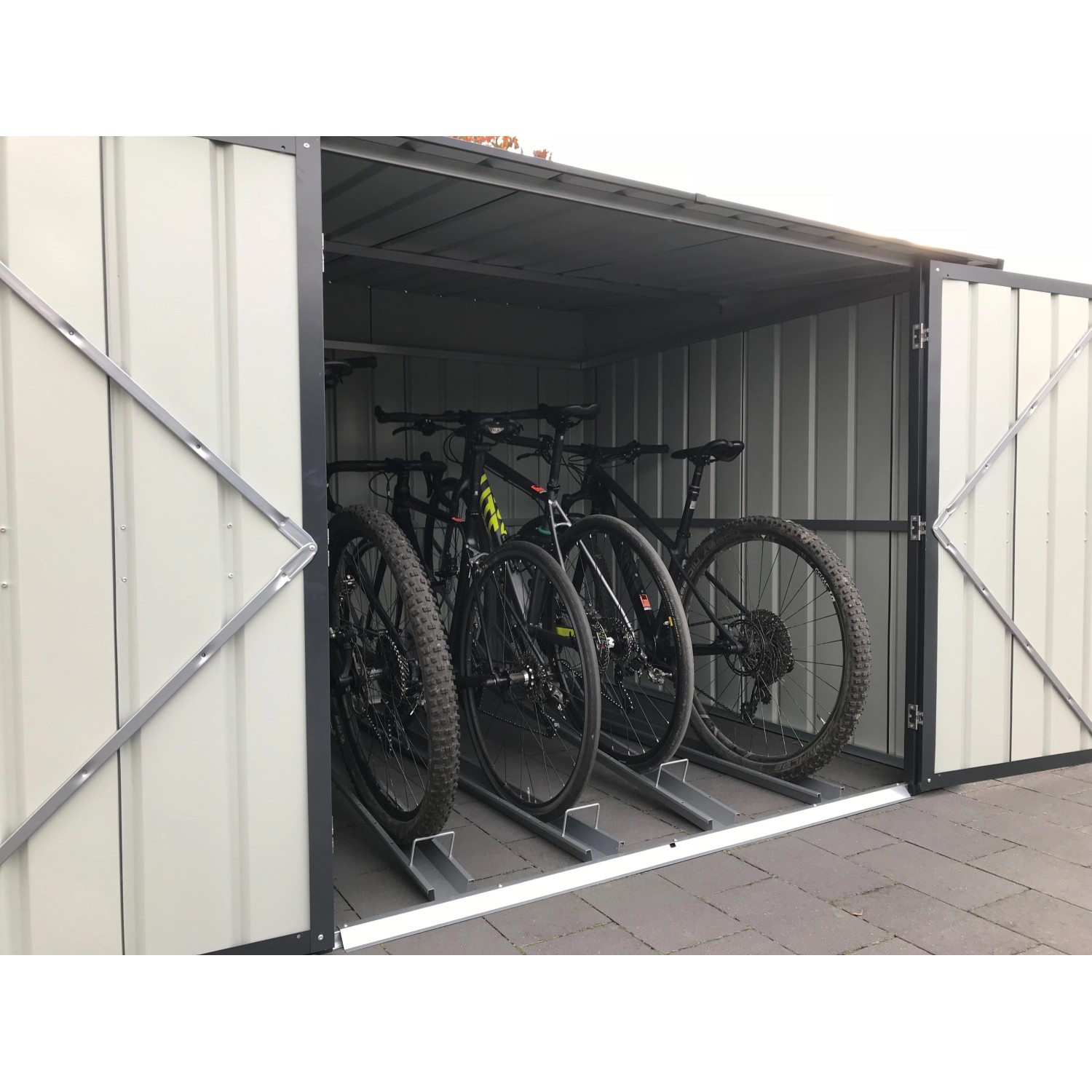 Geöffnete anthrazitfarbene Globel Fahrradbox Family mit 4 Fahrrädern und Fahrradhaltern.