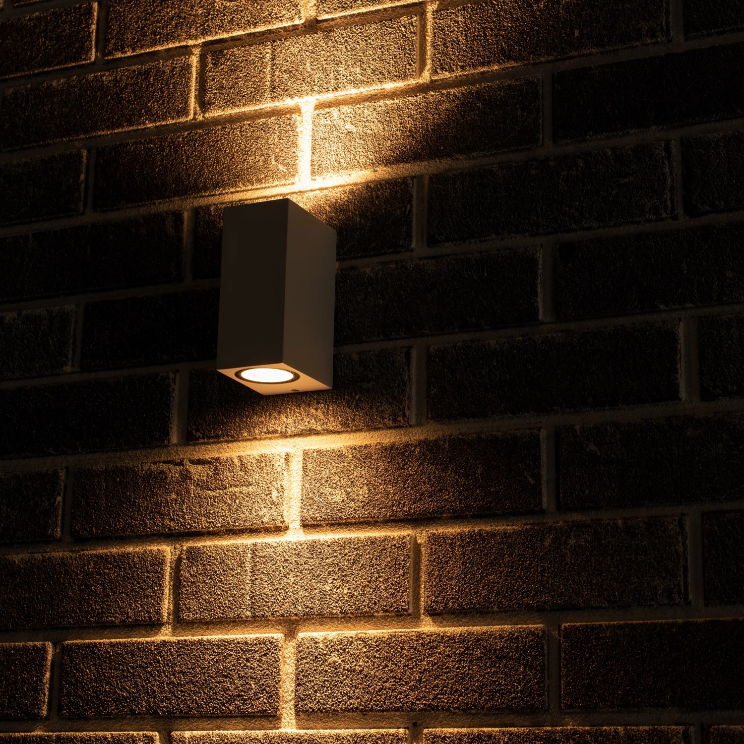 Weiße, eckige LED Außenwandleuchte (2-flammig) an einer Backsteinwand.