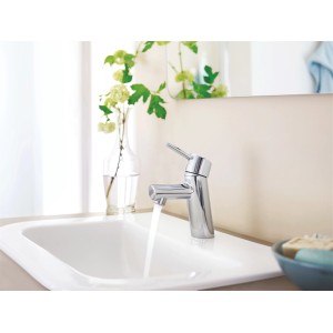 Grohe Concetto Waschtischarmatur in Chrom mit Wasserlauf auf weißem Waschbecken.