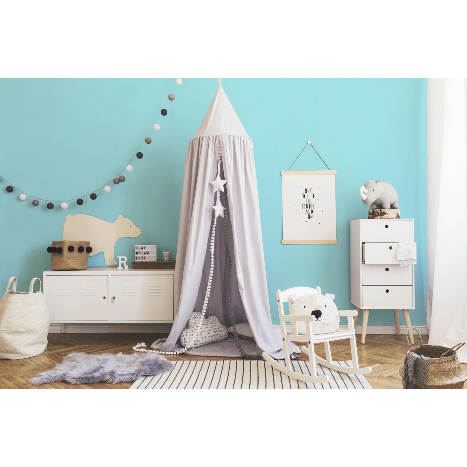 Kinderzimmer mit hellblauer Vliestapete Uni, Spielzelt, Schaukelstuhl und Kommode.