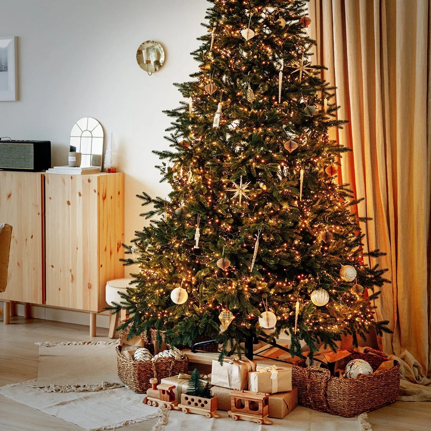 Geschmückter Weihnachtsbaum mit ECD Germany LED Büschel Lichterkette (warmweiß, 22m) und Geschenken im Wohnzimmer.