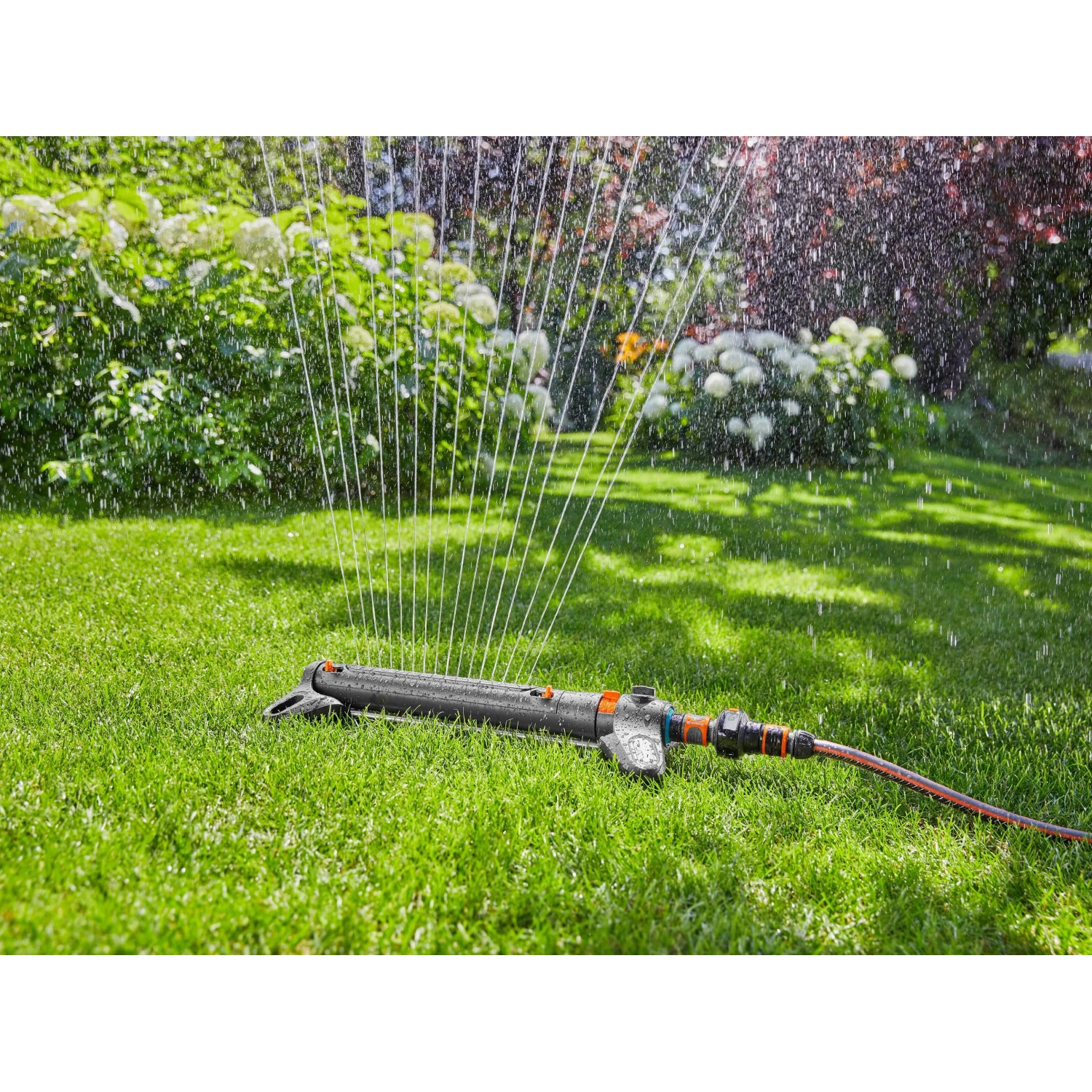 Gardena Viereckregner AquaZoom S beim Bewässern einer Rasenfläche.