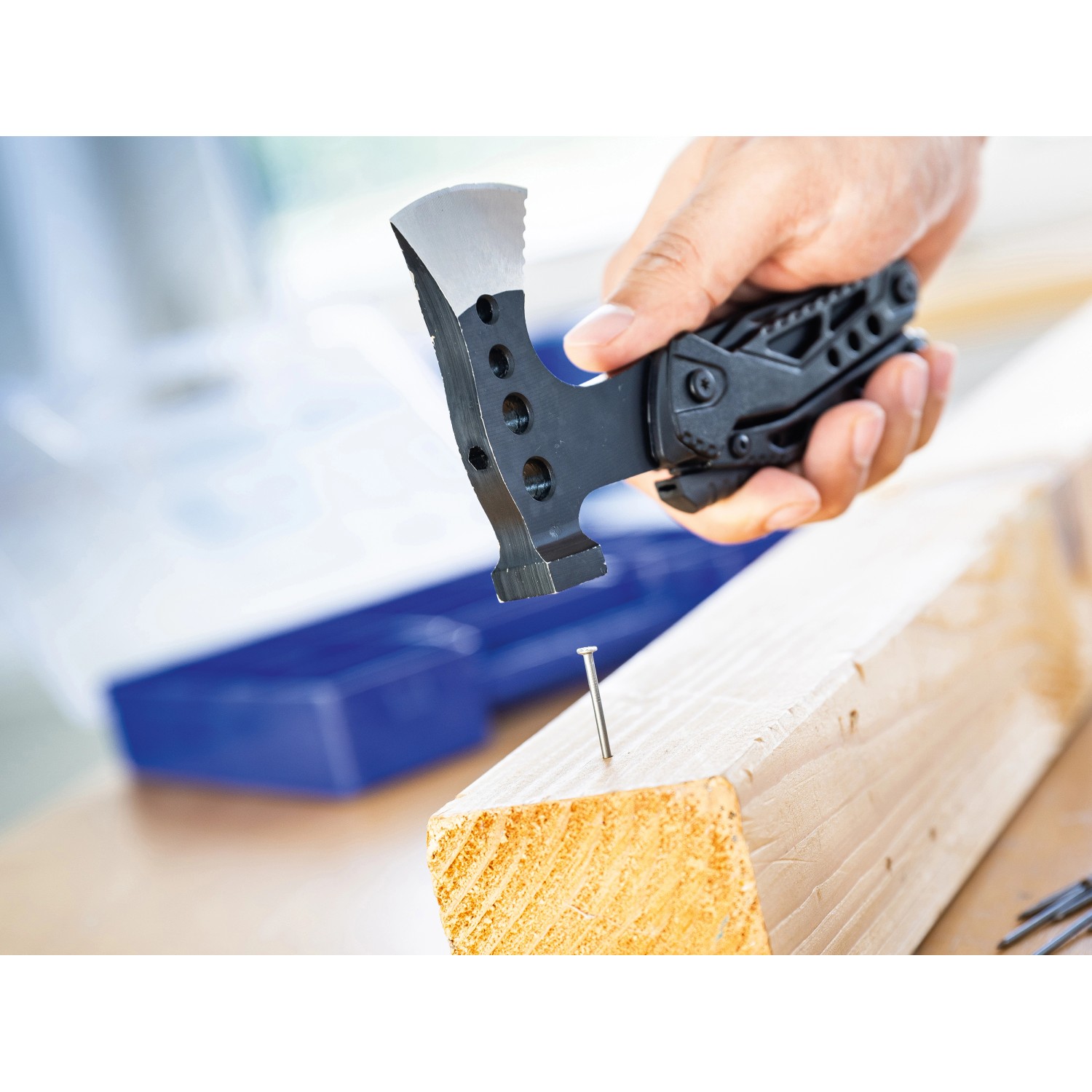 LUX Multi-Tool Axt Zange beim Einschlagen eines Nagels in Holz.