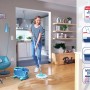 Frau wischt Holzboden mit Leifheit CLEAN TWIST Disc Ergo Wischmopp mit Rollen.