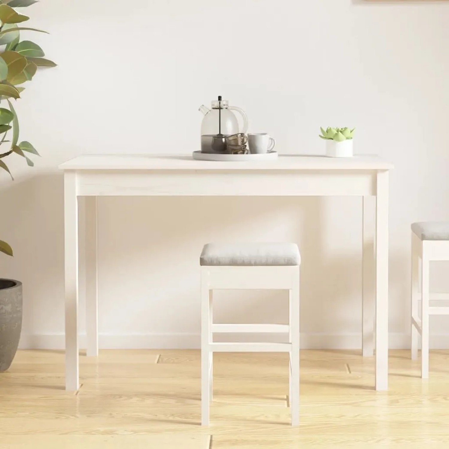 Weißer Esstisch aus massivem Kiefernholz im minimalistischen Design, mit Hocker und Teekanne. Ideal für Küche oder Esszimmer.