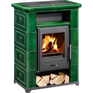 Grüner Wamsler Montafon Kaminofen (7 kW) mit Keramikverkleidung und Holzscheiten im unteren Fach.