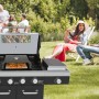 EL Fuego Pizzaaufsatz auf Grill mit Pizza, im Garten mit entspannten Personen.