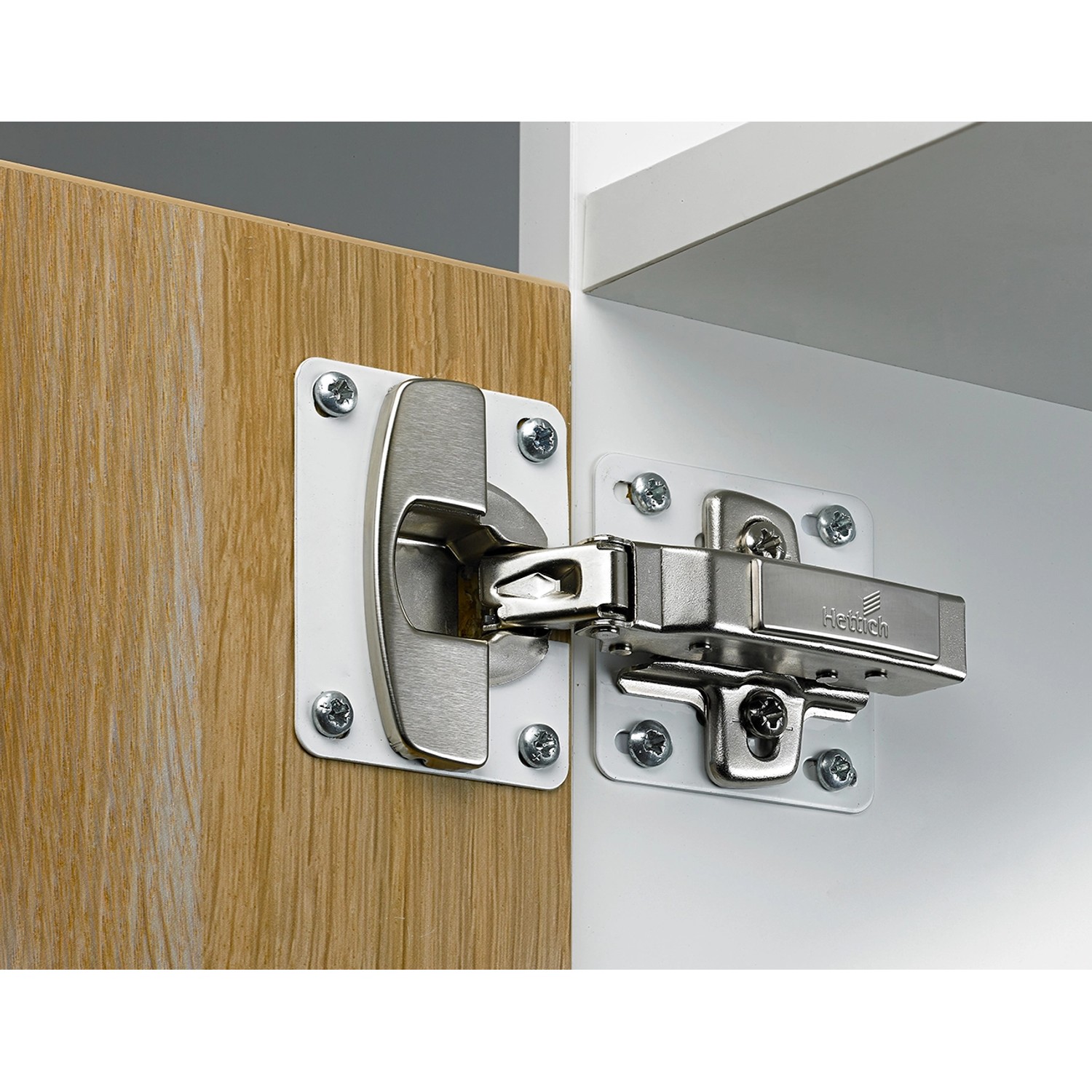 Hettich Reparaturblech, weiß, für 35 mm Topfscharniere an einer Möbeltür befestigt.