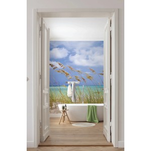 Komar Fototapete Ocean Breeze in Blau/Grün im Badezimmer mit Badewanne und Meerblick.