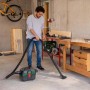 Mann saugt mit dem Bosch Akkusauger AdvancedVac 18V-8 Werkstattboden. Nass- & Trockensauger mit Zubehör.