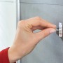Anbringen eines Tesa Powerstrips Haken Waterproof Zoom Edelstahl Small an einer grauen Wand im Badezimmer.